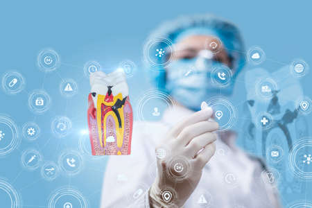 Concept Dental treatment with medications. Doctor holding a pill on the background of a sick tooth.の写真素材