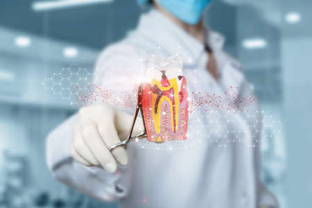 Dental surgical treatment concept. Doctor doing surgery on a sick tooth on a blurred background.の写真素材