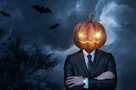 Business man with pumpkin head for halloween on blurred background.の写真素材