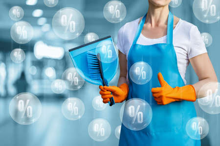 Concept of discounts for cleaning services. Cleaning lady on the background of flying bubbles with percent.の写真素材