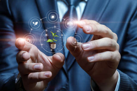 Business man hands interact with alternative energy sources on blurred background.の写真素材