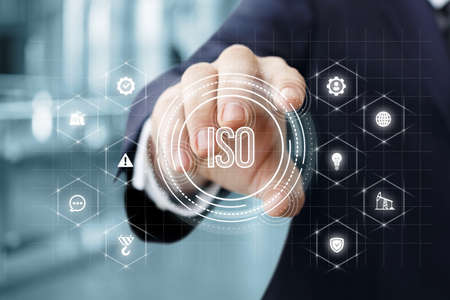 Business man on a virtual computer screen works with the ISO standards system.の写真素材