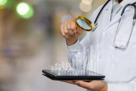 Doctor examine statistics using a magnifying glass on their tablet.