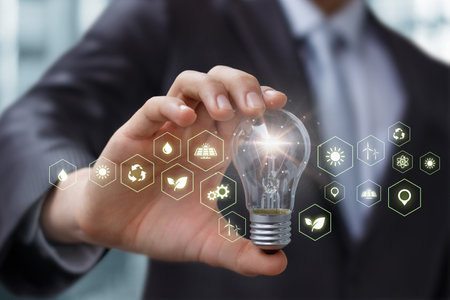 Concept of environmental protection ideas through business. Businessman holding a burning light bulb...