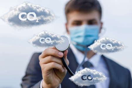 Atmosphere and environment treatment concept from CO2.Man listens to clouds with CO2 on the background of the sky.の写真素材