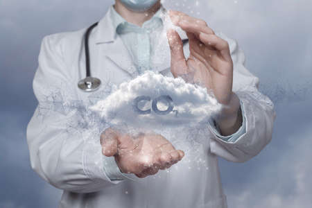 A scientist with a gesture protects against the spread of CO2 against a blurred background.の写真素材