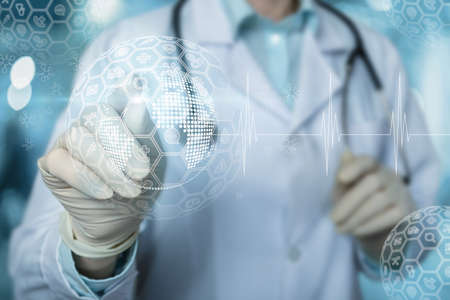 Doctor clicks on a virtual screen on the structure of medical icons on a blurred background.の写真素材