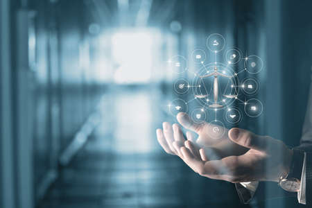 Concept of justice and legal services. Hands shows scales of justice and icons of justice services.の写真素材