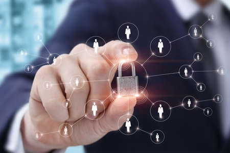 Business network protection installation concept. A businessman puts a padlock on a business...