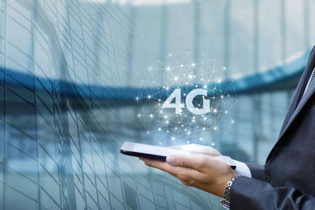 Business man shows on a 4G tablet in the network on a blurred background.の写真素材
