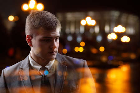 Young businessman thinking in double exposure on the night city.の写真素材
