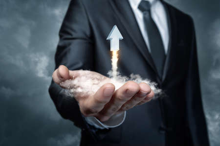 Concept of start up in business. A businessman supports a flying Arrow in the form of a rocket on a...