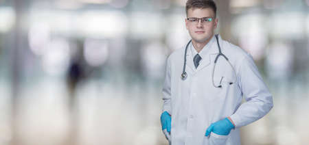 Medical worker man in gloves stands on a blurred background.の写真素材