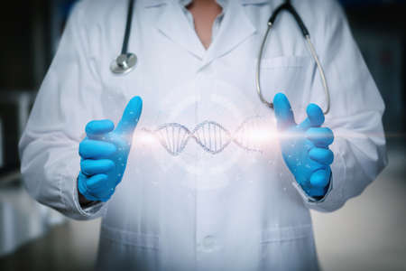 The doctor manipulates the DNA molecule on a blurred background.の写真素材