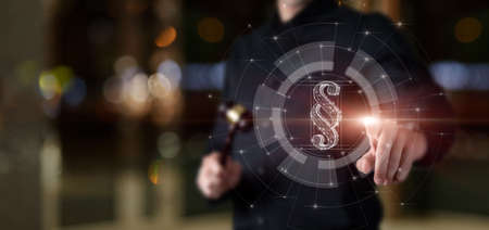 A lawyer with a judge gavel in his hands clicks on a paragraph on a virtual computer screen.の写真素材