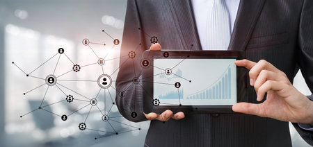 Businessman showing financial growth charts on blurred office background.