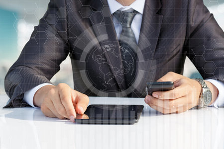 Businessman works using modern mobile devices at the table.の写真素材