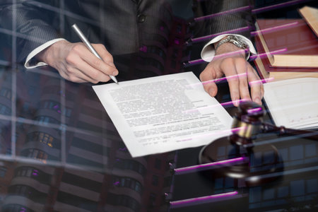 The concept of legal support in the signing of documents. Lawyer signs a document on a blurred...