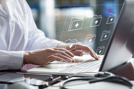 Doctor working on laptop with electronic documents on a blurred background.の写真素材
