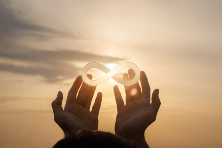 Hands support the sign of infinity on the background of the sun.の写真素材