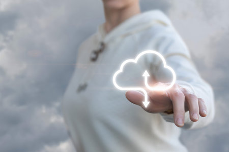 The concept of data exchange on the Internet. A woman clicks on the button for receiving and transmitting data against the sky.の写真素材