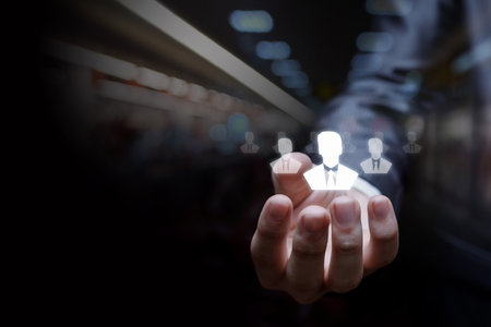 Businessman hand showing human resources icons on dark background.の写真素材