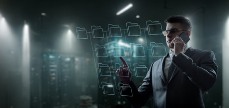 Businessman working on a virtual computer screen opening a document and talking on the phone.の写真素材