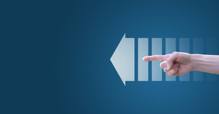 Direction sign concept. The hand indicates the direction along the arrow on a blue background.の写真素材