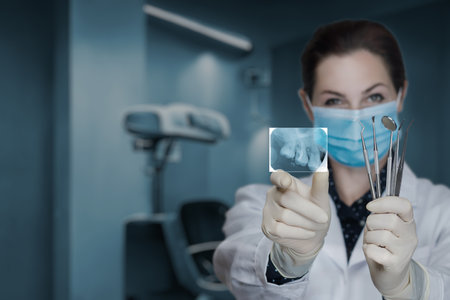 The doctor shows a picture of dental treatment on a blurred background.の写真素材
