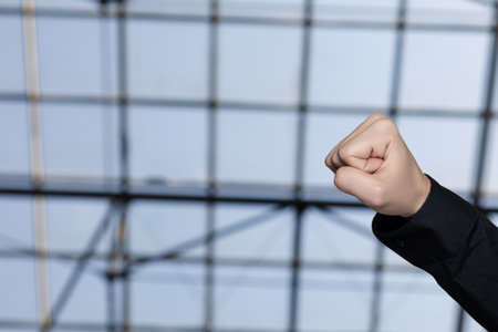 Raised fist as a sign of protest against the background of the window.の写真素材