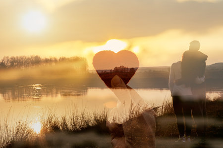 Double exposure Couple in love and hand showing heart on sunset background.の写真素材