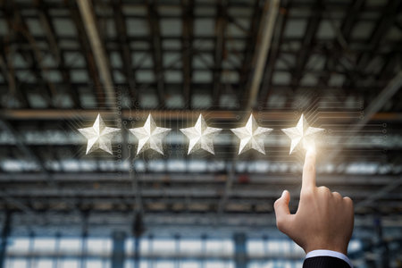 The concept of ranking in the industry. Hand clicks on the fifth star on the background of the factory ceiling.の写真素材
