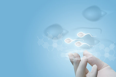 Concept of diagnosis and research of sperm donors. Hand shows sperm on a blue background.の写真素材