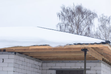 Unfinished roof covered with snow. The concept of snow load on the roof.の写真素材