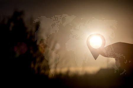 Concept of location in space. The hand shows the location icon against the sunset background.の写真素材