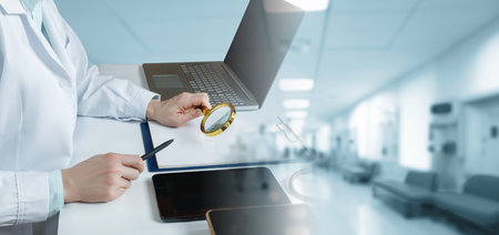 Doctor looking through a magnifying glass at documents in a modern office against a blurred...
