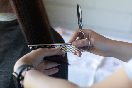 Hairdresser cutting the hair of a client on a background of a salon.の写真素材