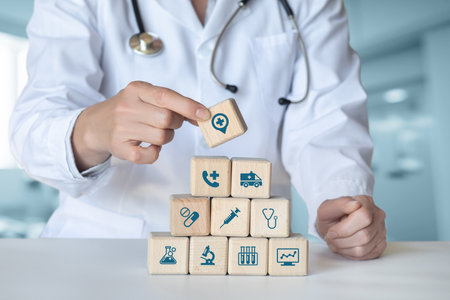 Doctor lays out cubes of medical service structure on blurred clinic background.の写真素材