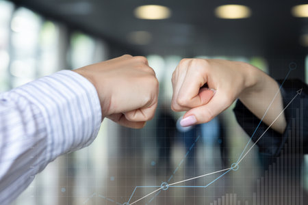 Businesswomen shake their fists in agreement with the financial growth in profits.の写真素材