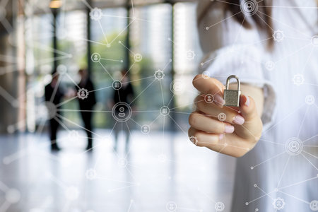 The concept of digital security. A woman's hand holds a padlock against the background of nets.の写真素材