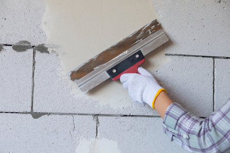 The craftsman levels the wall made of gas blocks with a spatula.の写真素材