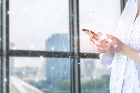 Mobile technology network. Girl with phone communicates on the network.の写真素材