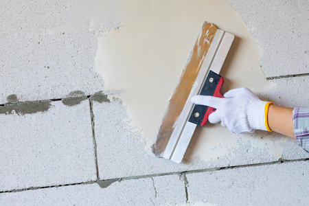 Puttying of walls by a craftsman. The process of leveling walls using a large spatula.の写真素材