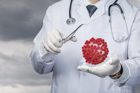 A medical professional in a white coat uses forceps to examine a red virus model in a laboratory. The background shows a dramatic sky, symbolizing the urgency in health research.の写真素材