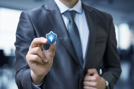 A business person dressed in a suit is displaying a digital icon representing security. The setting...