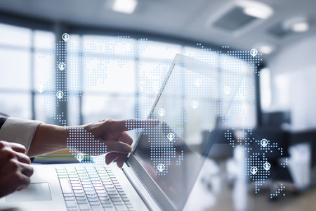 A person interacts with a laptop in a modern office setting, emphasizing digital security. The...