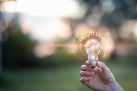 Bright ideas in hand. A person holds a glowing light bulb, symbolizing innovation and creativity...