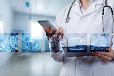 A doctor in a white coat studies medical scans while using a smartphone in a clinic.