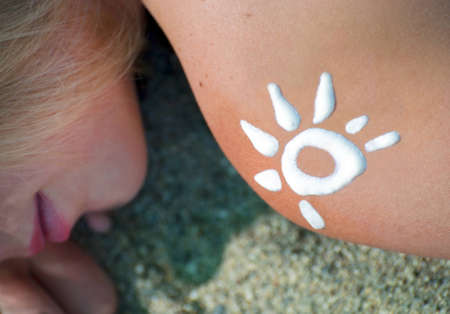 Sun from sun-protection cream on a shoulder at the girlの写真素材
