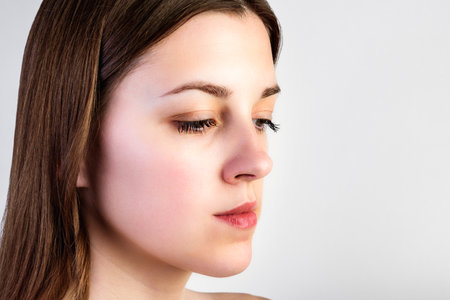 Beauty woman face portrait on gray background.の写真素材